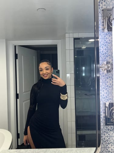 Reviewer taking a mirror selfie in a bathroom wearing the black Butter Contour High Slit Maxi Dress.