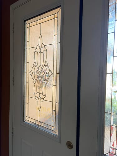 Customer's white door with the new 3/4 Lite Frame Kit neatly installed around decorative glass.