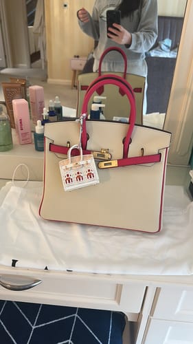 Customer's two-tone LALUVA Warkin Bag in cream and pink with gold hardware, sitting on a vanity.