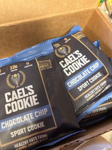 Customer's open box showing several Cael's Cookie Chocolate Chip sport cookies in their blue and black wrappers.