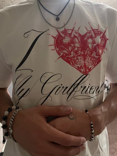 Close-up of a customer wearing the white "I Love My Girlfriend" shirt, showing the red spiky skull-heart graphic.