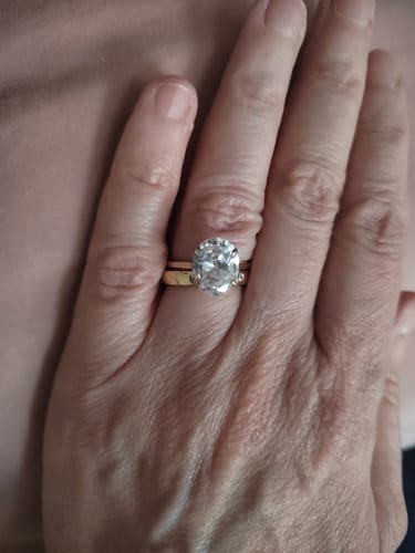 A close-up of a customer's hand wearing the elegant Oval Solitaire Travel Ring.