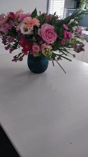Customer's Country Garden Bouquet of pink and white flowers arranged in a dark blue vase.
