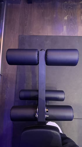 Kundenansicht des B2 LegMaster-Aufsatzes von oben, die die schwarzen Polsterrollen auf einer Trainingsmatte zeigt.