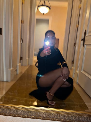 Partial view of a reviewer crouching in the black maxi dress, with a bright camera flash obscuring the shot.