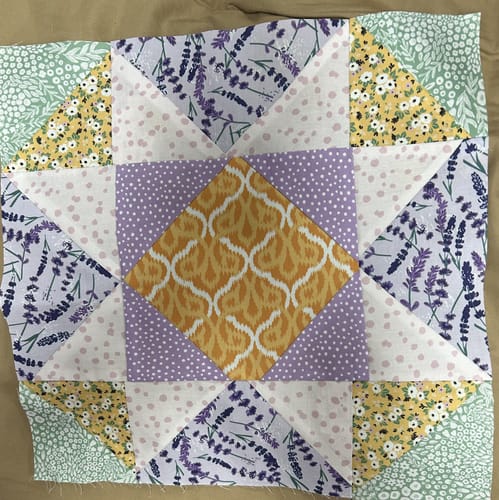 Reviewer's completed quilt square showing the varied fabrics from their Mrs Quilty Subscription Box.