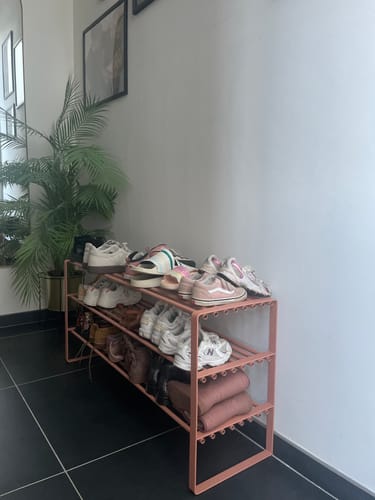 Recensent toont het Spinder Design schoenenrek Rex SR 2 in Clay Terra, gevuld met schoenen in een hal.