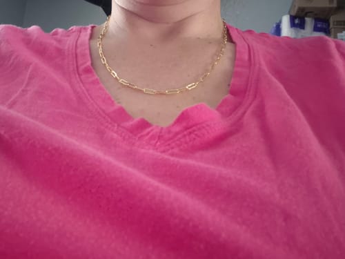 Customer wearing the gold Tammy Paperclip Chain Necklace against a pink shirt.