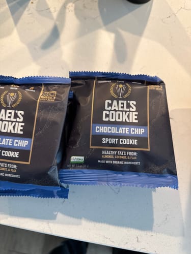 Reviewer's two packages of Cael's Cookie Chocolate Chip sport cookies resting on a countertop.
