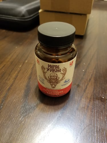 Reviewer's amber bottle of Primal Viking Testosterone Support on a wooden table.