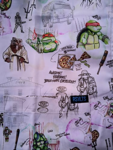 Close-up of a reviewer's 'Heroes in a Half Sketch' shirt, showing the detailed sketchbook-style print of TMNT characters.