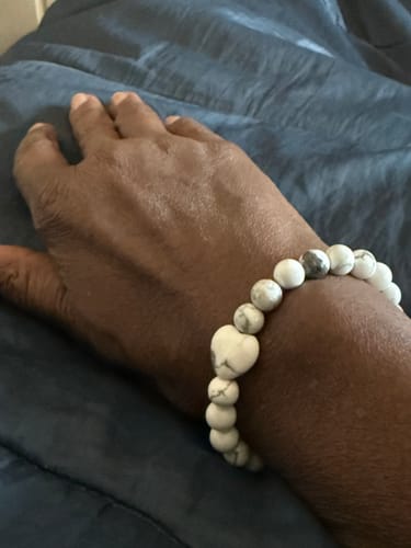 Customer wearing a white Howlite bracelet with a heart-shaped bead on their wrist.