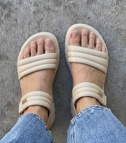 Customer wearing The Align sandals in a light beige color, shown from a top-down perspective with jeans.