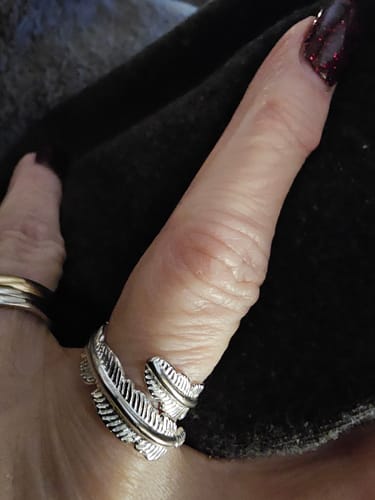 Close-up of a customer wearing the silver Feather From An Angel Ring on their thumb.