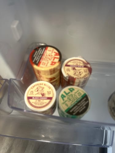 Customer's Sweet Nectar Nicotine Pouches stacked with various other ALP pouch flavors inside a refrigerator door.