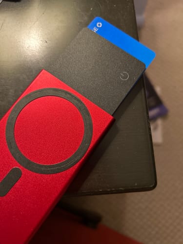 Reviewer's black SPOTMINDERS Tracking Card shown inside a red phone wallet next to a credit card.