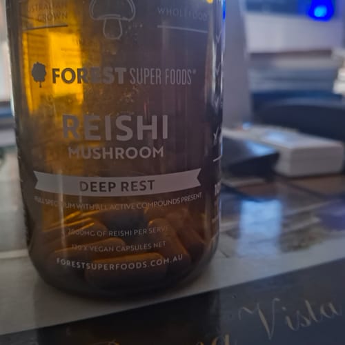 Reviewer's close-up of a brown bottle of Reishi Mushroom Capsules, with the capsules visible inside.
