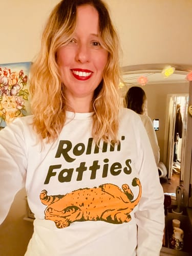 Reviewer smiling while wearing the white Rollin' Fatties Long Sleeve Tee.