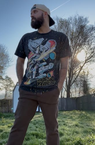 Reviewer showing the fit of a size medium Star Wars 'Built to Rebel' vintage tee while standing outdoors.