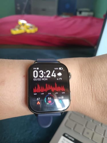 Reviewer's smartwatch with a blue band on their wrist, showing the health tracking display.