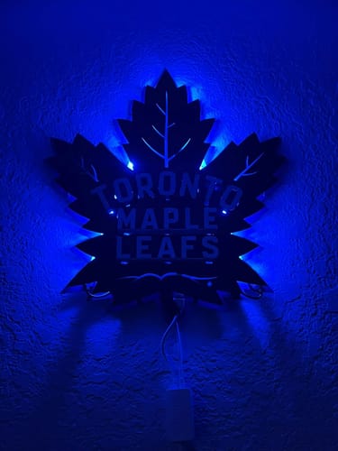 Customer's Toronto Maple Leafs metal wall art illuminated by blue LED backlighting on a wall.