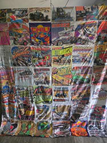 Customer's large Project Repat T-Shirt Quilt made from a collection of colorful car racing shirts.
