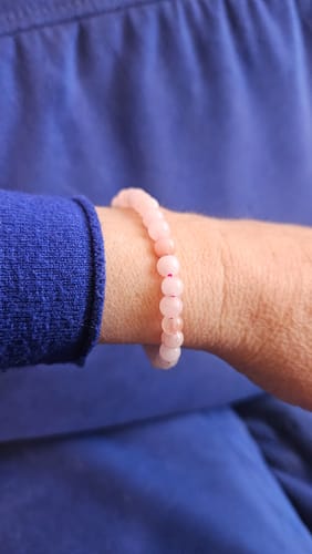 Cliente portant son bracelet en opale rose délicat au poignet.