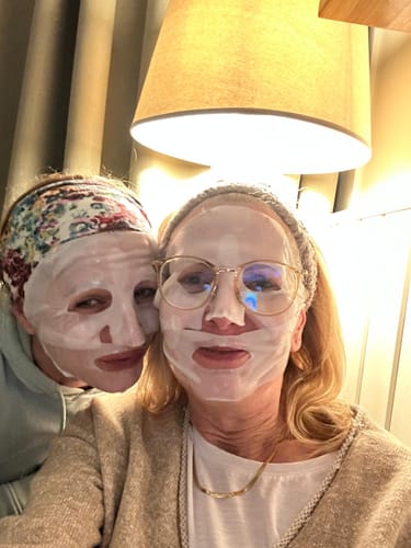 Zwei Rezensentinnen mit aufgetragener Kollagen Boosting Maske bei einer gemütlichen Anwendung zu Hause.