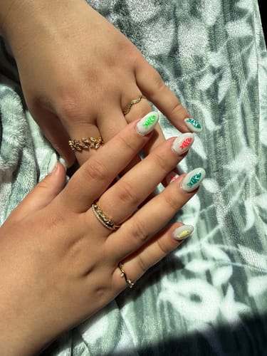 Reviewer's hands displaying several delicate gold rings from the product bundle.