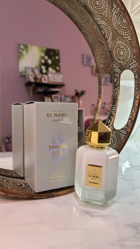 Customer's white Tahara perfume bottle with a gold cap displayed with its box on a vanity.