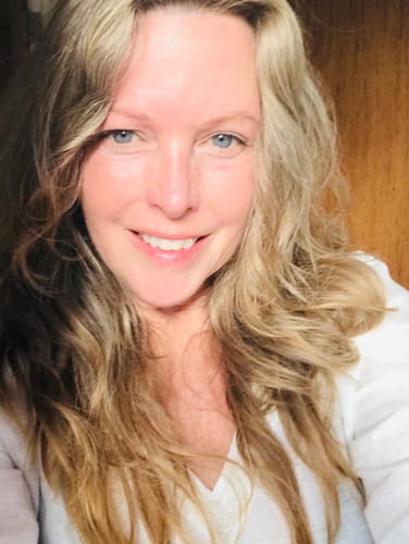 A close-up of a smiling reviewer showing her clear skin after using S-Balm.