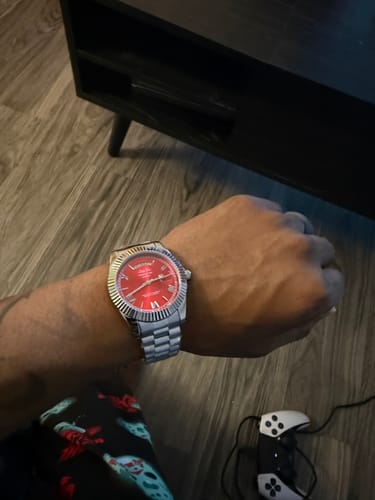 Customer wearing the Lucky Fours® Santos watch on their wrist, showing the red dial and silver band.
