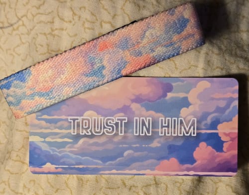Customer's Trust In Him Bible Verse Bracelet and its matching card, both showing a beautiful pink and blue cloudy sky design.