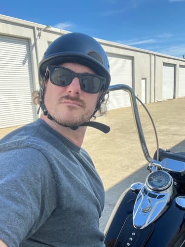 Reviewer on a motorcycle showing the low fit of their black Switchback DOT Reversible Helmet.