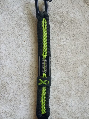 Customer's Mental Health Awareness Paracord Bracelet in dark gray and lime green, showing the awareness tag and ribbon.