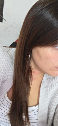 Primer plano del cabello de una clienta, que se ve brillante y suave tras usar el Spray Bifásico 10 en 1.