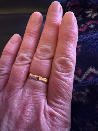 Customer's hand wearing the gold Bamboo Ring on their ring finger.
