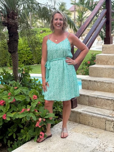 Reviewer smiling while standing on outdoor stone steps in a tropical setting.