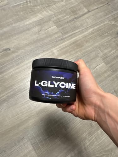Customer holding a black tub of L-Glycine.