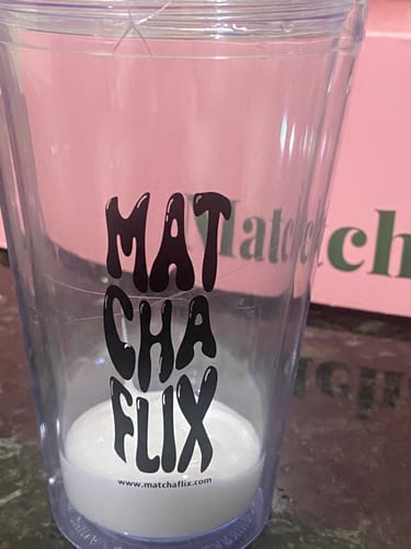 Cliente preparando un Cúrcuma Latte, comenzando con una base blanca líquida en un vaso transparente.