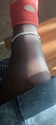 Close-up of a reviewer's ankle wearing the beaded Festival Anklet.