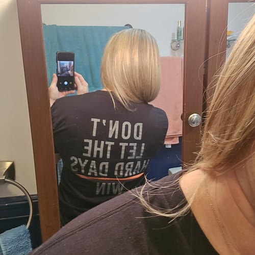 Reviewer shows the back of their black Keep Going t-shirt, which reads, "Don't Let The Hard Days Win."