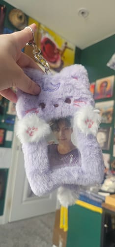 Customer holding the purple plush cat photocard holder, which displays a photo through a clear window.