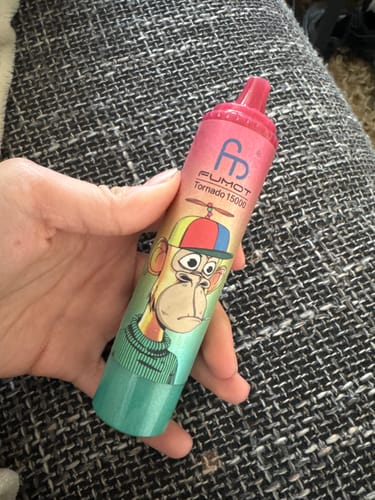 Ein Rezensent hält den bunten RANDM TORNADO 15000 mit einer Cartoon-Affen-Grafik in der Hand.