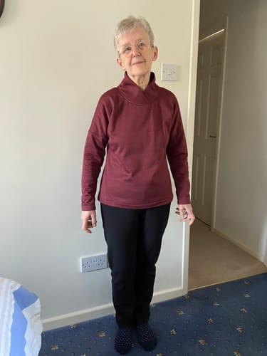 Reviewer wearing a finished sweatshirt with a high collar, made from the Wine Melange Sweatshirt Fabric.