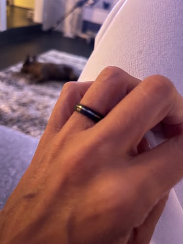 Close-up of a reviewer's hand wearing a black ring with a shiny inlay.