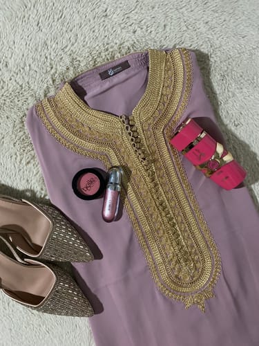 Customer's mauve Caftan Luna 2 with gold embroidery, styled in a flat lay on a rug with accessories.
