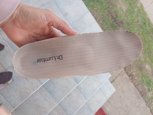 Értékelő a kezében tart egy Ortopéd Pro talpbetétet.