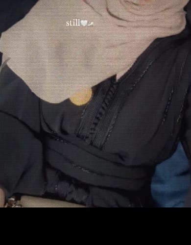Close-up of a reviewer wearing the black Malika kaftan, showing the detailed front embroidery and belt.