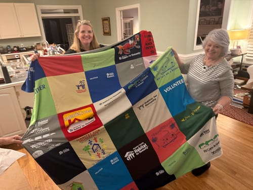 Customers proudly displaying their colorful Premium T-Shirt Quilt made from Habitat for Humanity t-shirts.